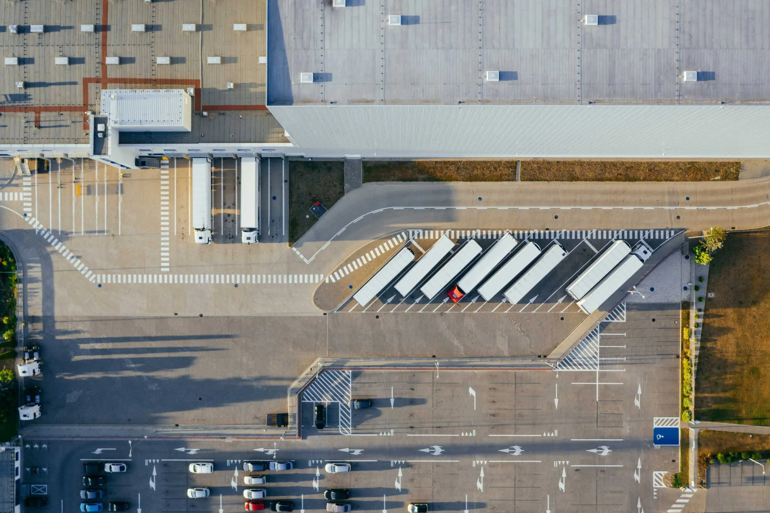 Delivery trucks parked outside a warehouse, shot from above